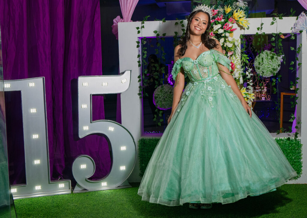 foto de una chica con vestido color menta posando al lado de un numero 15. La decoración indica que esta cumpliendo años. Fue tomada en el Salon de eventos del ispfa. Maracay, Aragua.