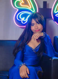 Chica sentada con vestido azul.